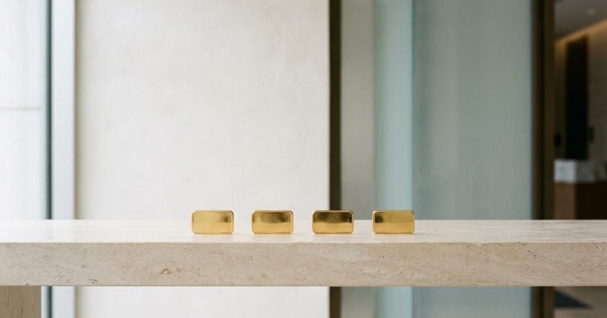 Concept illustration of identical gold bars in a level row on a cream stone ledge